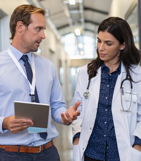 Doctor and collegue discuss ai adoption in hospital hallway