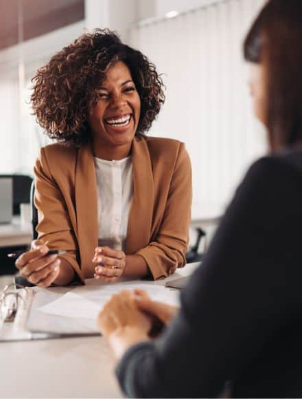 Financial advisor with a cheerful demeanor discussing options with a client, highlighting the efficient and secure environment provided by cloud fax solutions.