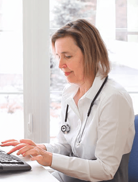 Physician using a computer for cloud fax integration, streamlining digital communication in healthcare.